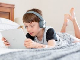 Boy using iPad with headphones on