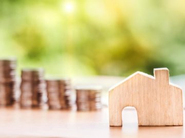 wooden house with piles of coins in the background